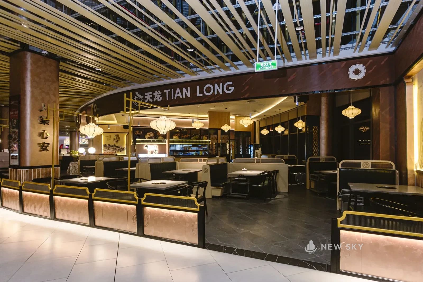 Gian hàng Tian Long mở thẳng ra hành lang Aeon Huế, ranh giới với lối đi chung dựng bằng dãy ghế booth và biển hiệu Tian Long phía trên.